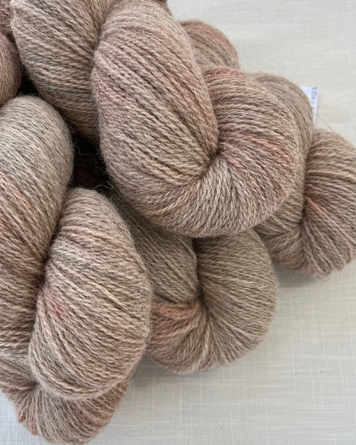 Skeins of soft pink toned sustainable British 4ply wool naturally dyed with plants for knitting