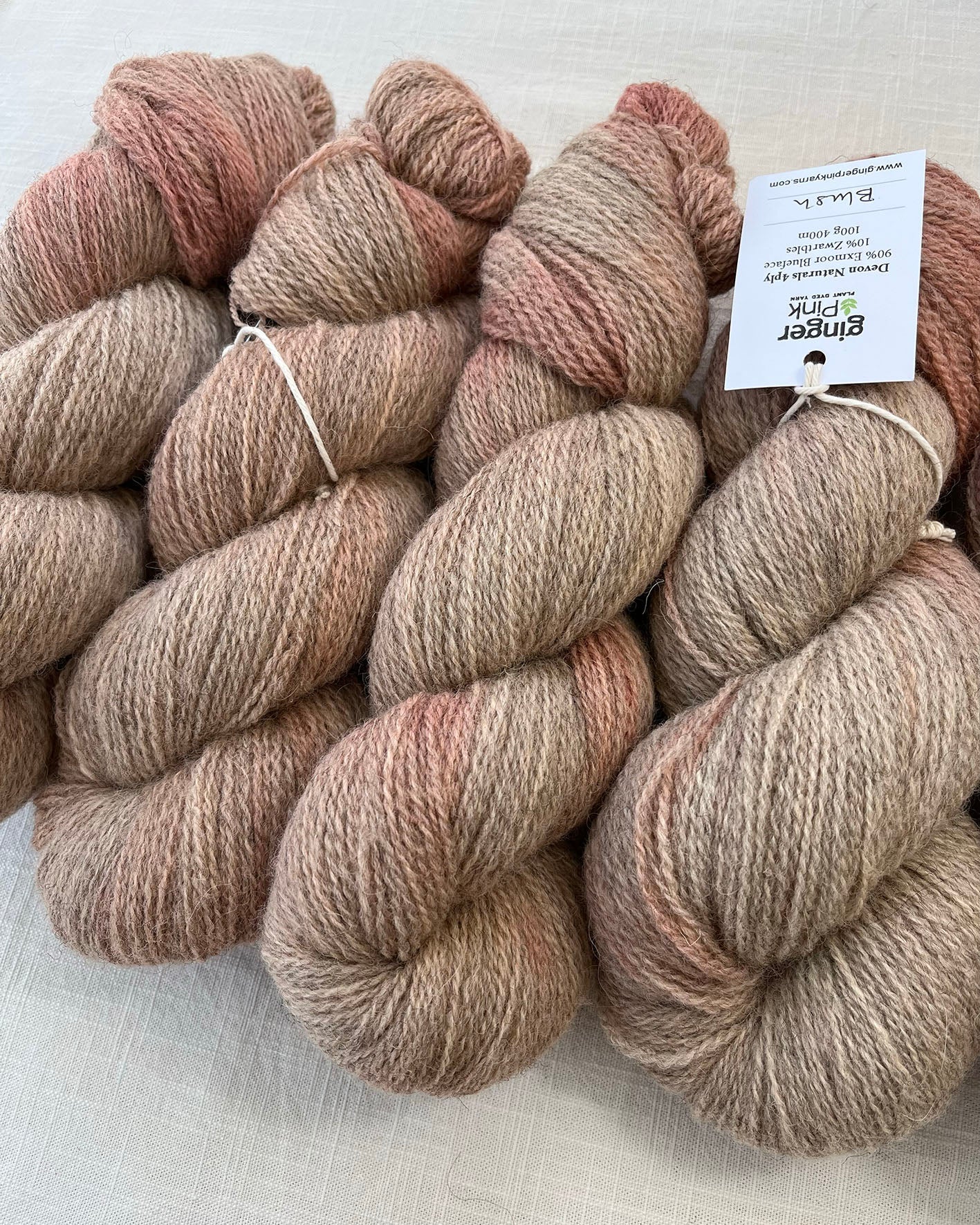 Skeins of soft pink toned sustainable British 4ply wool naturally dyed with plants for knitting