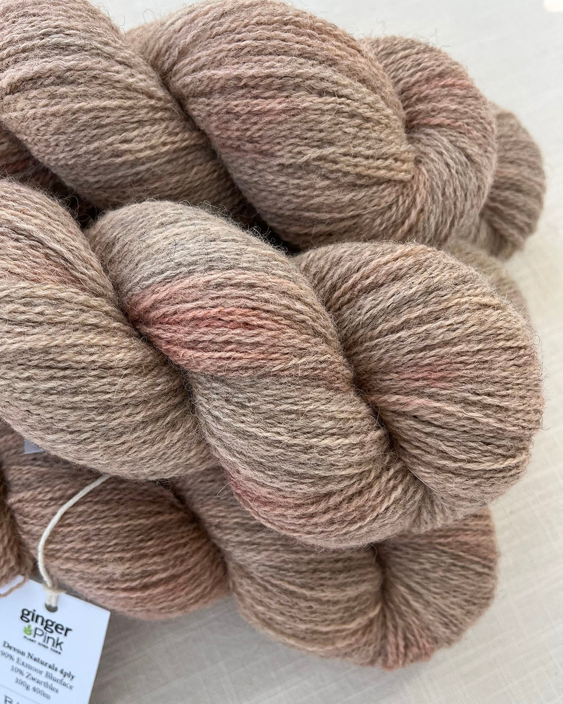 Skeins of soft pink toned sustainable British 4ply wool naturally dyed with plants for knitting