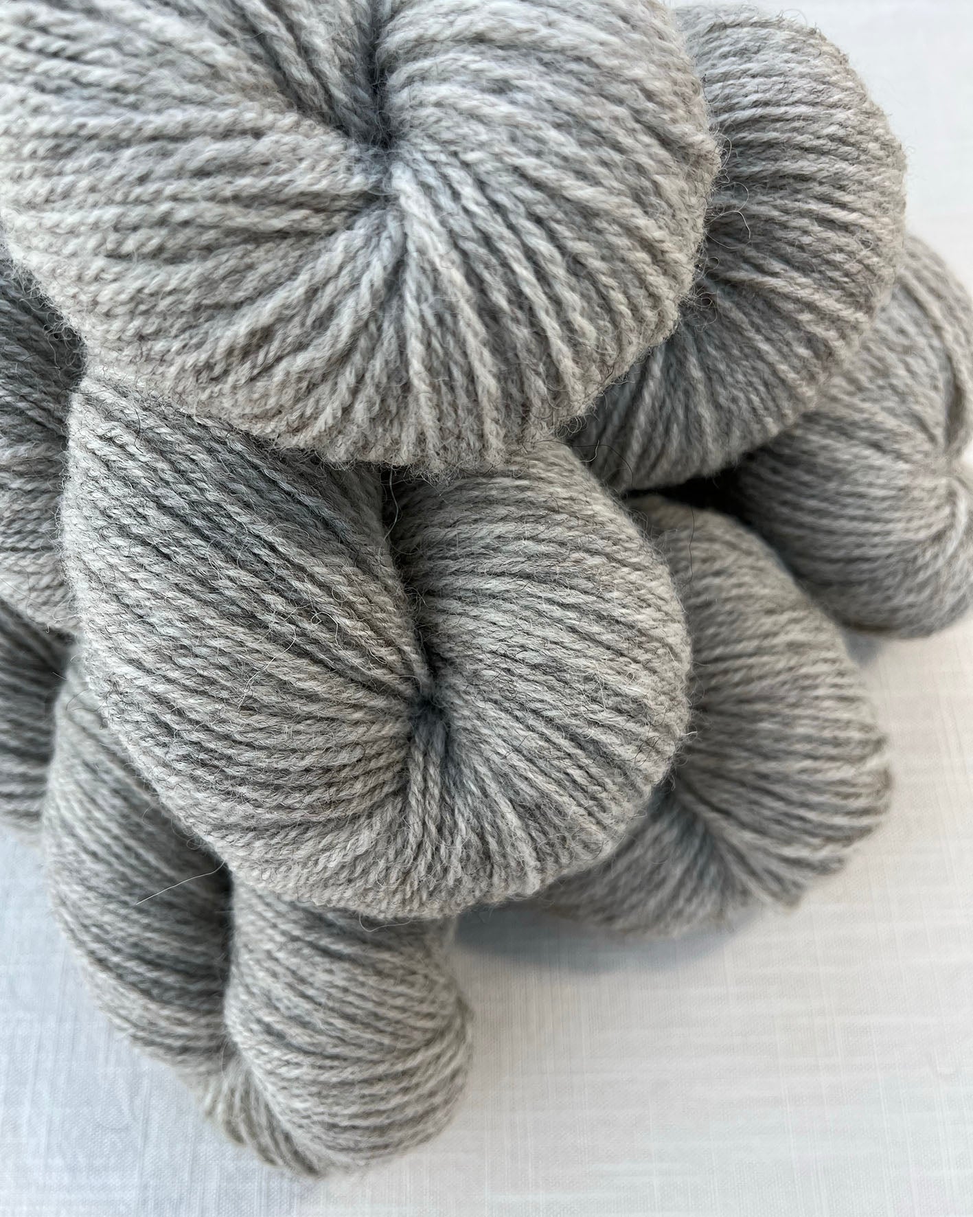 Skeins of soft grey toned sustainable British DK wool naturally dyed with plants