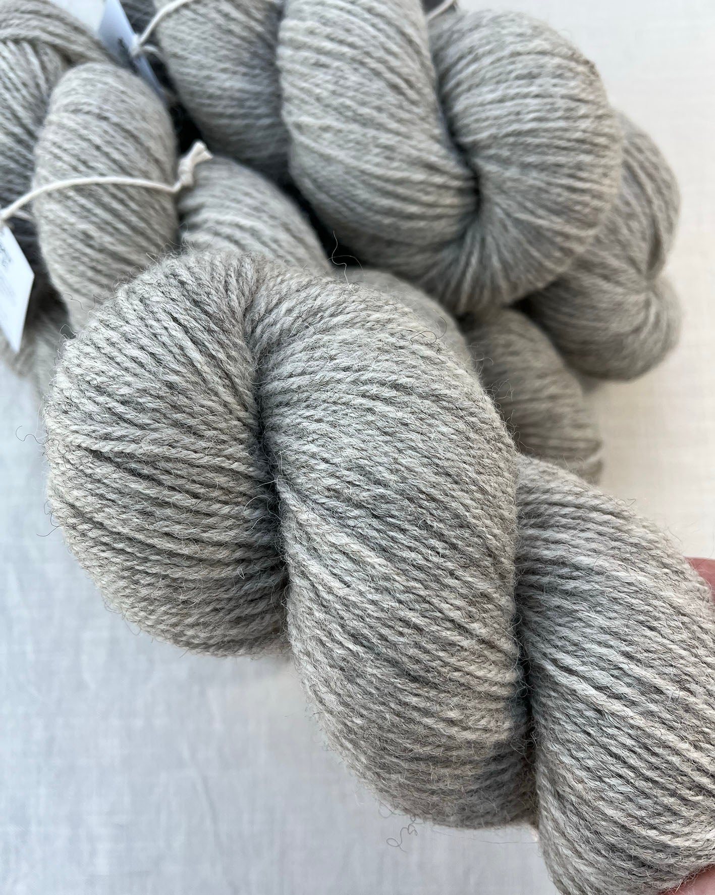 Skeins of soft grey toned sustainable British DK wool naturally dyed with plants