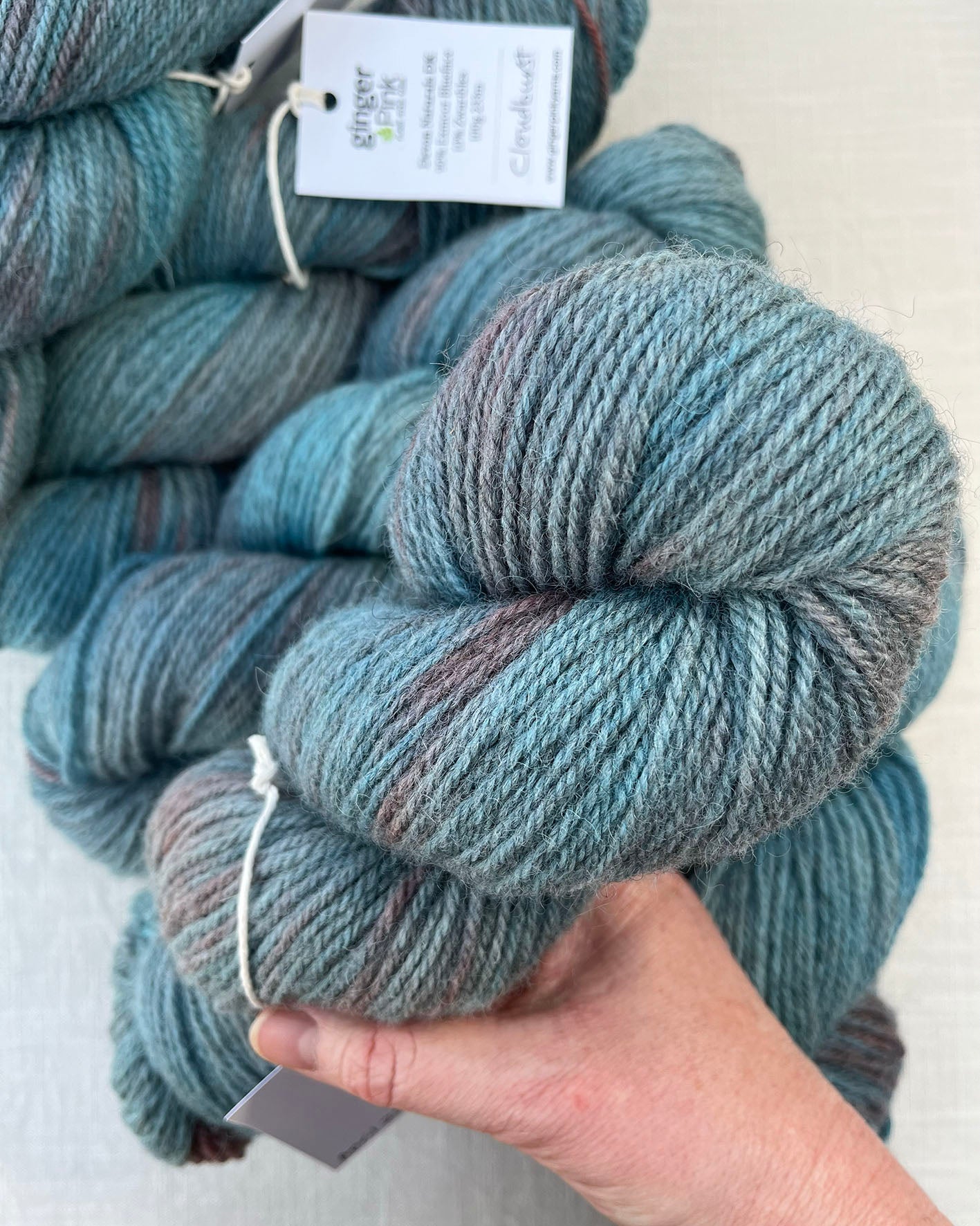 Skeins of soft blue and pink toned variegated sustainable British DK wool naturally dyed with plants