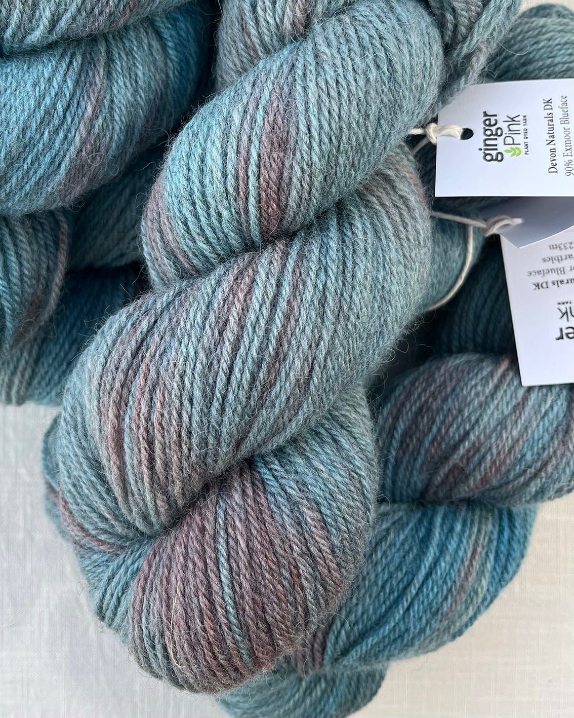 Skeins of soft blue and pink toned variegated sustainable British DK wool naturally dyed with plants