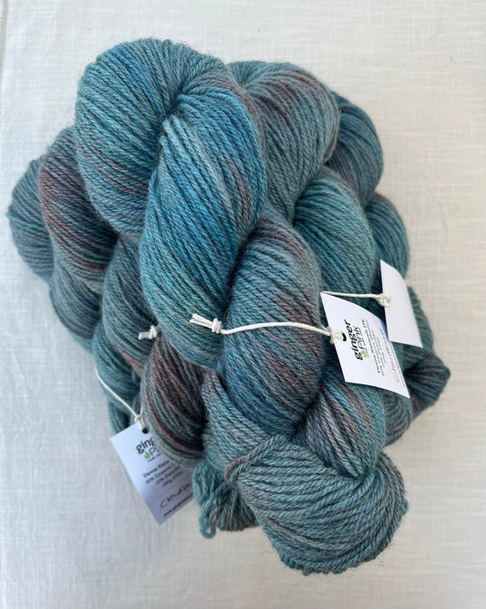 Skeins of soft blue and pink toned variegated sustainable British DK wool naturally dyed with plants