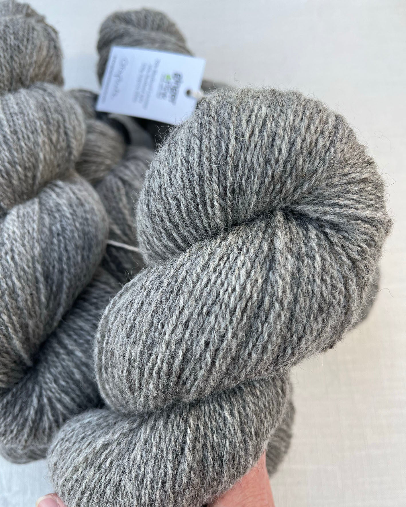 Skeins of soft graphite grey toned sustainable British Shetland 4ply wool naturally dyed with plants