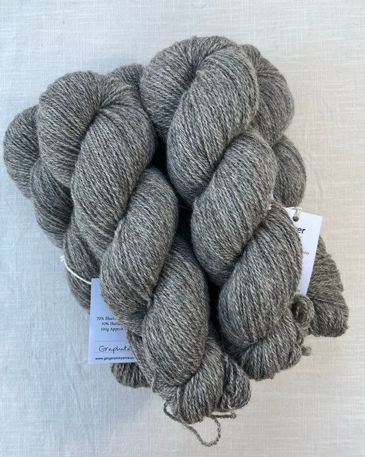 Skeins of soft graphite grey toned sustainable British Shetland 4ply wool naturally dyed with plants