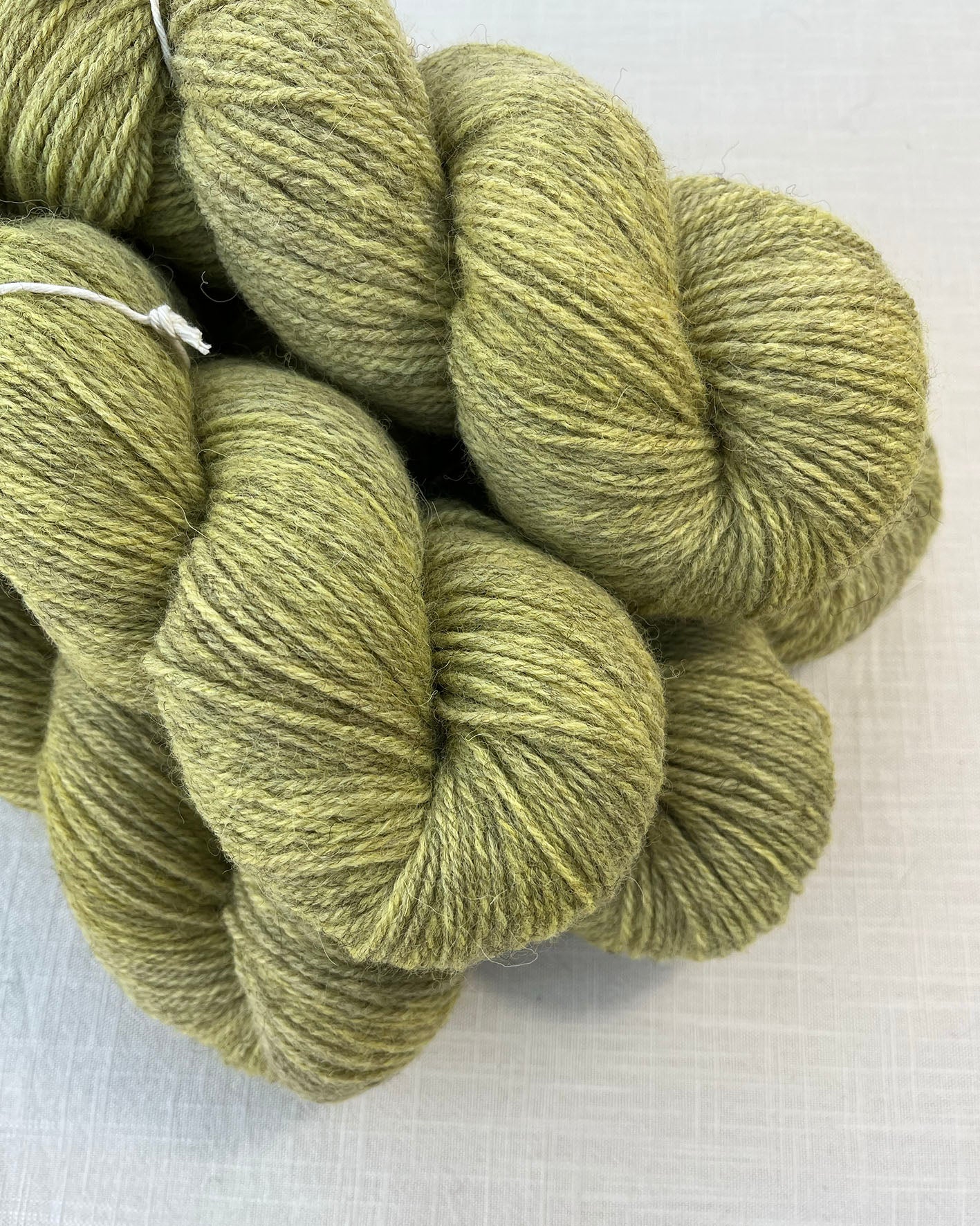 Skeins of soft Sorbet green and yellow toned sustainable British DK wool naturally dyed with plants
