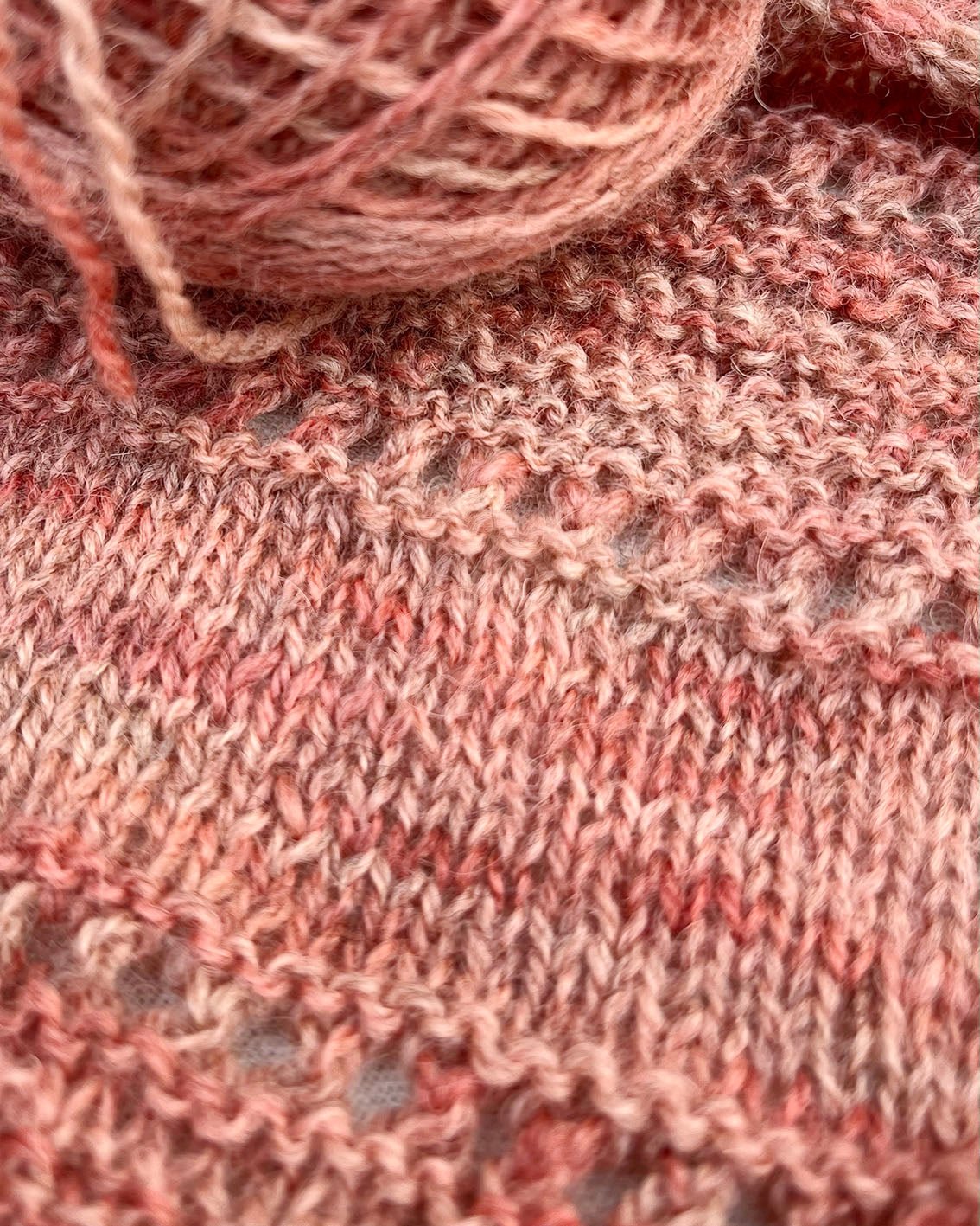 Skeins of soft pink toned variegated sustainable British 4ply wool naturally dyed with plants for knitting