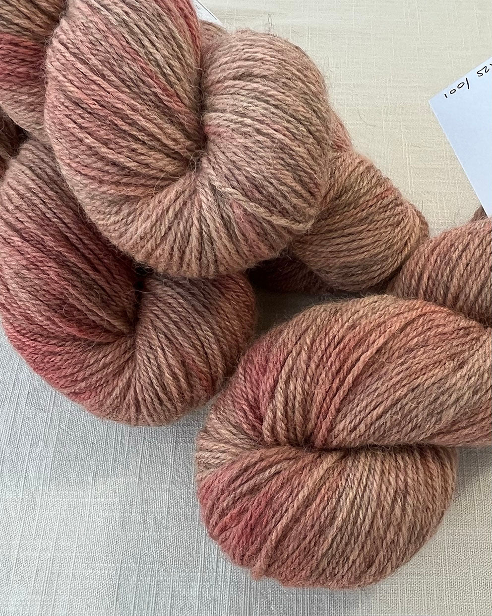 Skeins of soft pink toned semi-solid sustainable British DK wool naturally dyed with plants for knitting