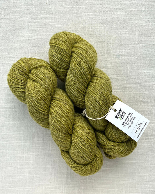 Skeins of vibrant soft green toned sustainable British 4ply wool naturally dyed with plants for knitting
