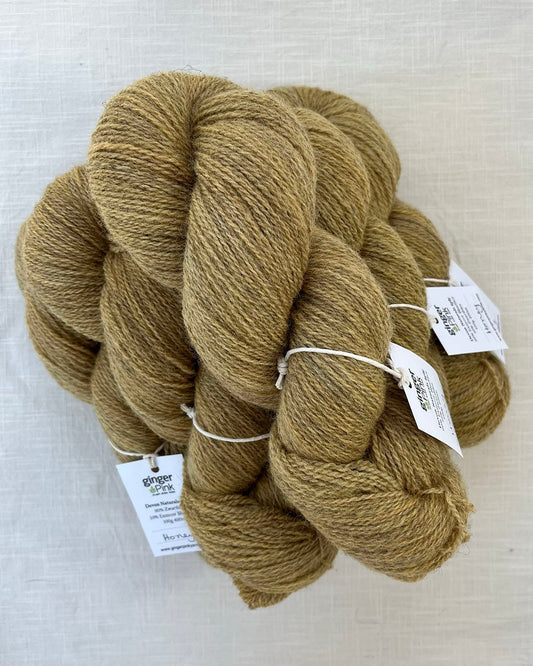 Skeins of soft honey toned sustainable British 4ply wool naturally dyed with plants