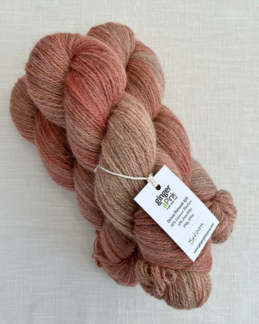 Skeins of soft pink toned variegated sustainable British 4ply wool naturally dyed with plants for knitting